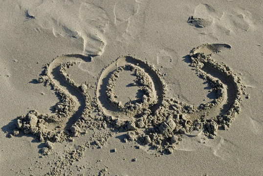 SOS字樣寫(xiě)在沙