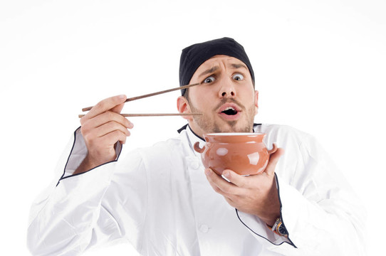 驚訝的年輕廚師擺碗和筷子