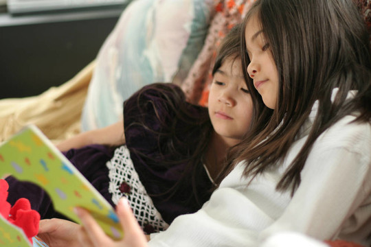 兩個(gè)女孩讀一本書