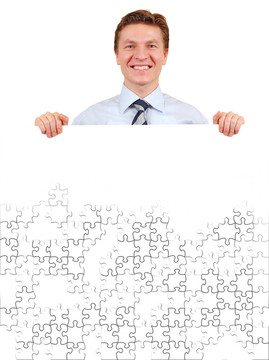 微笑的商人拿著白色未完成的拼圖板；添加你的文字或圖像