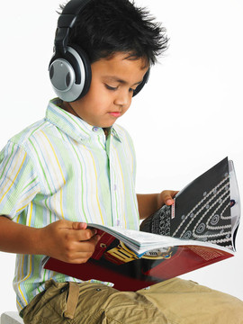 男孩聽音樂讀一本書