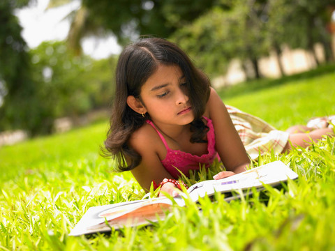 女孩在公園里讀一本書