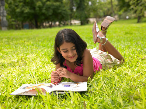 女孩在公園里讀一本書