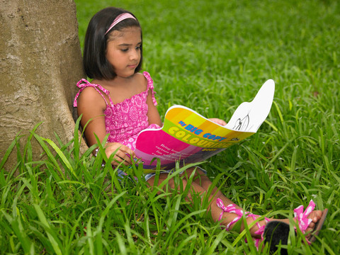 女孩在公園里讀一本書