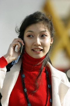 一個(gè)帶手機(jī)的亞洲年輕女孩的畫像