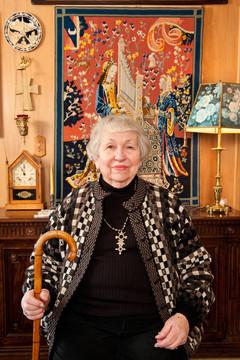 86歲的婦女在她的家；持有甘蔗