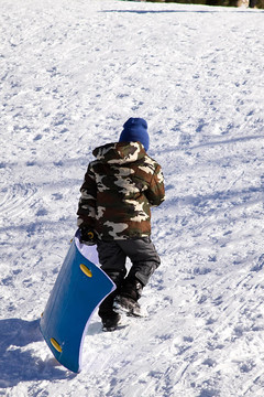小男孩坐雪橇滑下Hill