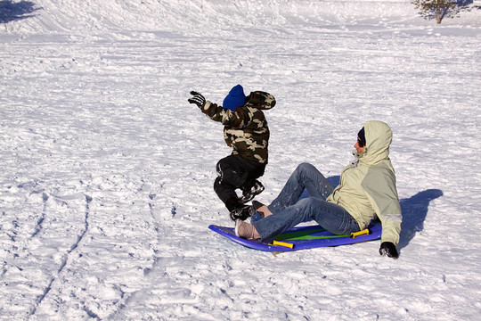 母親和兒子坐雪橇滑下Hill