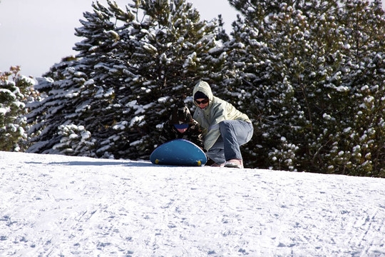 母親和兒子坐雪橇滑下Hill