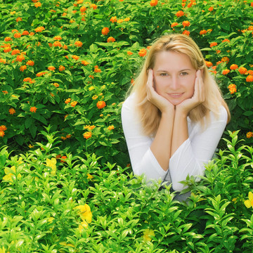 年轻的女人坐在花丛中