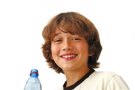 微笑的十幾歲的男孩在drinkng水