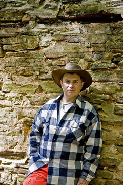 Plaid人和橙靠在巖壁