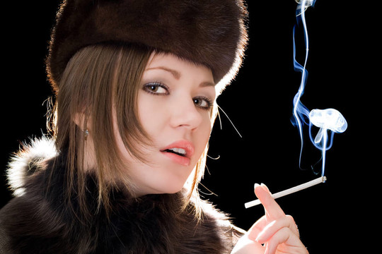 美麗的年輕女人的肖像與香煙