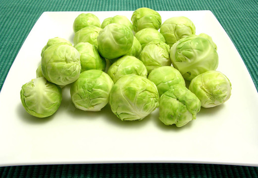 布魯塞爾豆芽排列的白色板和綠色的餐墊