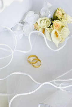 結婚戒指鮮花和新娘包過面紗
