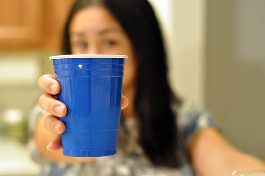 一位年輕女子提供的藍(lán)色塑料派對杯