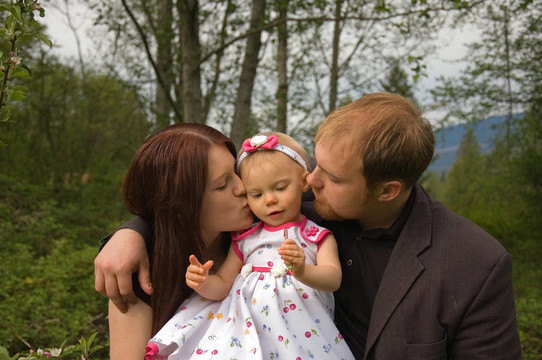 媽媽和Dad Kissing Toddler