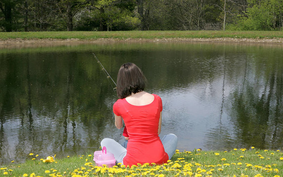 女人在池塘邊釣魚(yú)