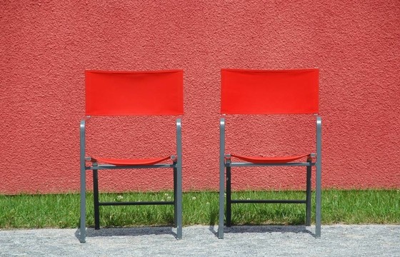 在一個紅色的墻前兩紅cheairs