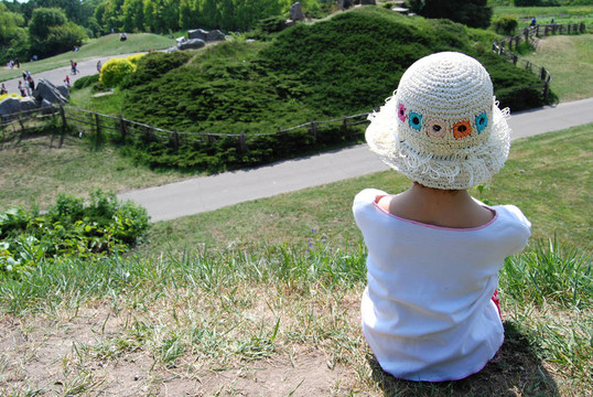 小女孩坐在公園的青山上