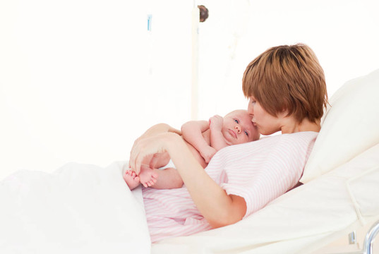 母親吻她的新生嬰兒