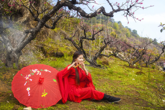桃花林邊吹笛子的古裝美女
