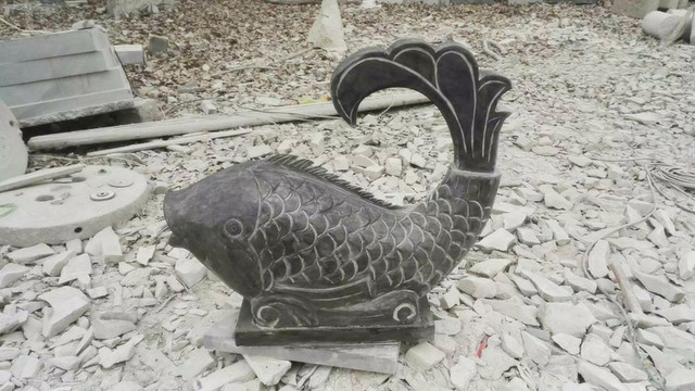 石雕魚(yú)立于跳龍門(mén)深色魚(yú)雕塑
