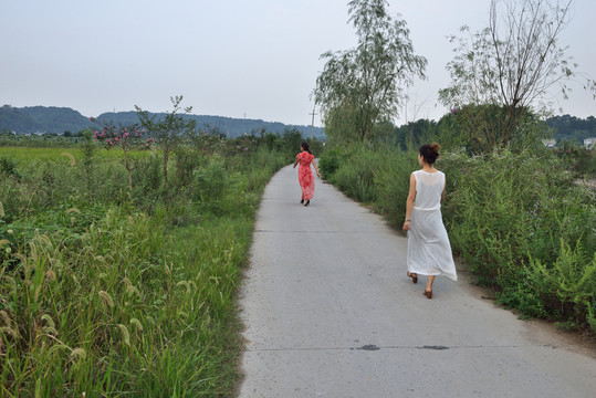美女走在鄉(xiāng)間小道上