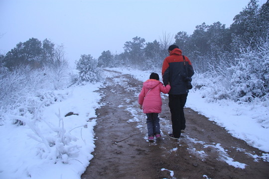 雪景中爸爸陪女兒散步