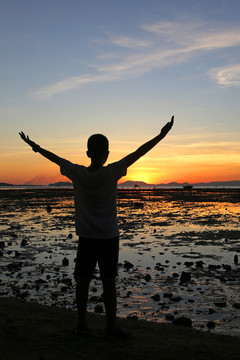 海邊 面向夕陽的少年