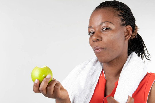 穿着运动装的女人吃苹果