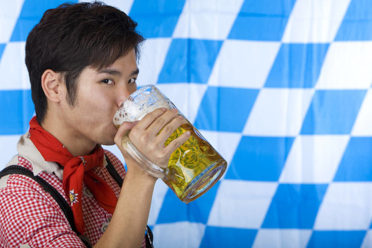 中國男人的皮褲喝啤酒從啤酒杯