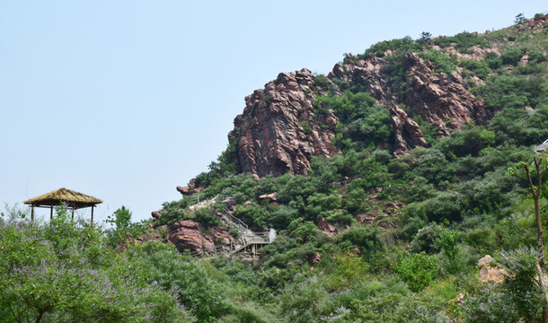 紅色石頭山峰和草亭