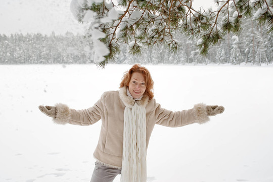 女人成熟的成人快樂的冬天森林的雪自然