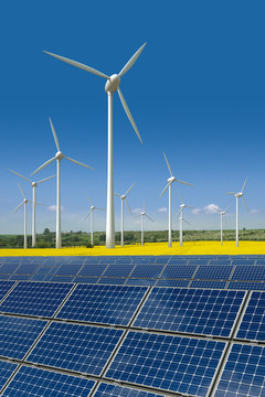 風(fēng)力渦輪機(jī)和太陽能電池板在油菜田里