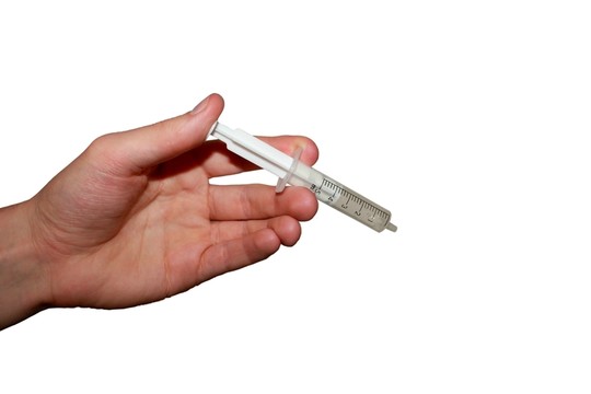 用注射器的手