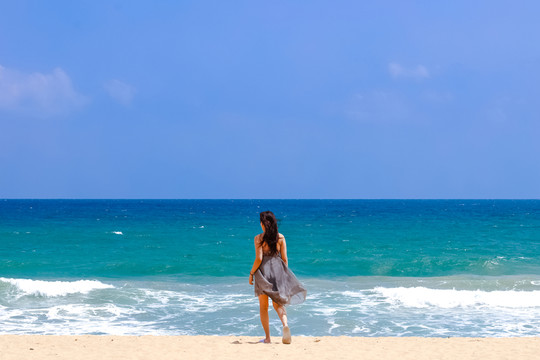 沙灘上面朝大海的女人背影