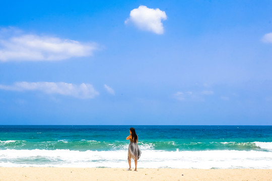 沙灘上面朝大海的女人背影