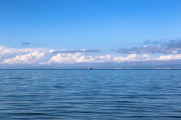 青海湖的湖邊遠處依稀可見郵輪