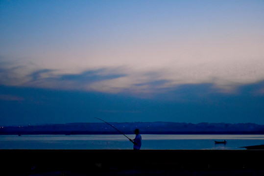 夕陽時分橋上的釣魚人