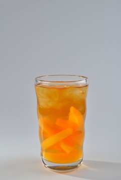 裝在玻璃杯里的黃桃蜂蜜茶