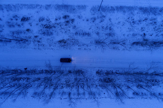 越野車在雪原夜色道路上行駛
