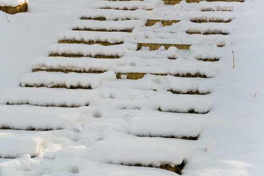 公園里冬天落滿積雪的大理石臺階