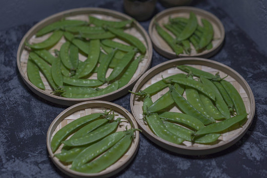 水泥背景草編盤(pán)中的荷蘭豆蔬菜