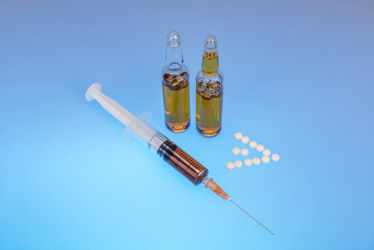 一只吸滿藥水的注射器和兩瓶針劑
