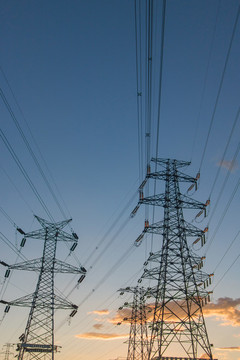 城市日落下的高壓線塔電力系統(tǒng)