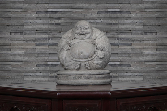 中式桌子上的彌勒佛石頭雕像