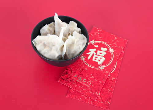 紅背景上一碗餃子和紅包