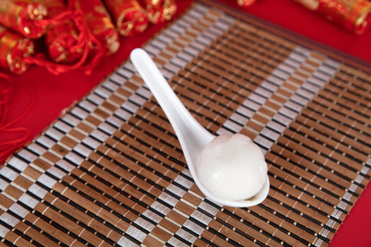 竹墊子上的勺子和勺子里的湯圓