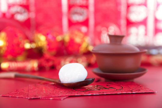 喜慶紅背景上的蓋碗茶和盛著湯圓